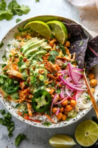 Salsa chicken Instant Pot served in a white bowl, topped with cilantro-lime crema and fresh cilantro